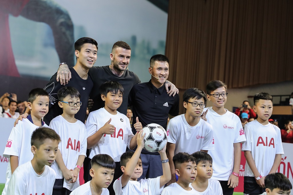 Đại sứ thương hiệu AIA toàn cầu Beckham chụp ảnh với tuyển thủ Duy Mạnh, cựu danh thủ Lê Công Vinh và các em nhỏ