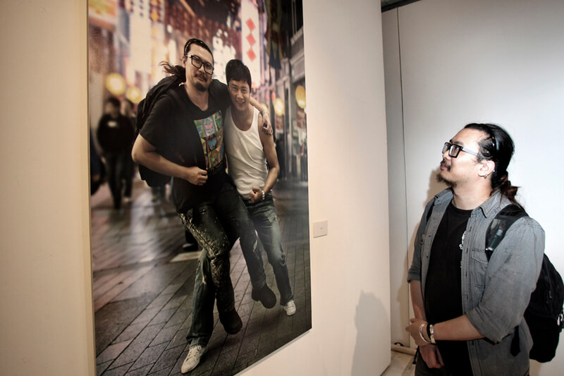 Nhiếp ảnh gia Kurt Tang bên tác phẩm của mình