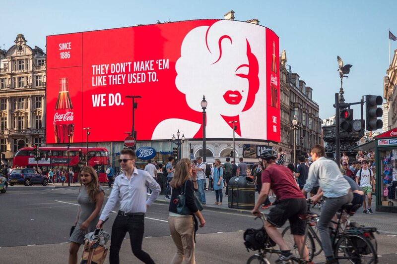 Một tấm biển quảng cáo ngoài trời OOH tại thủ đô London trong chiến dịch "We Do" của Coca-Cola